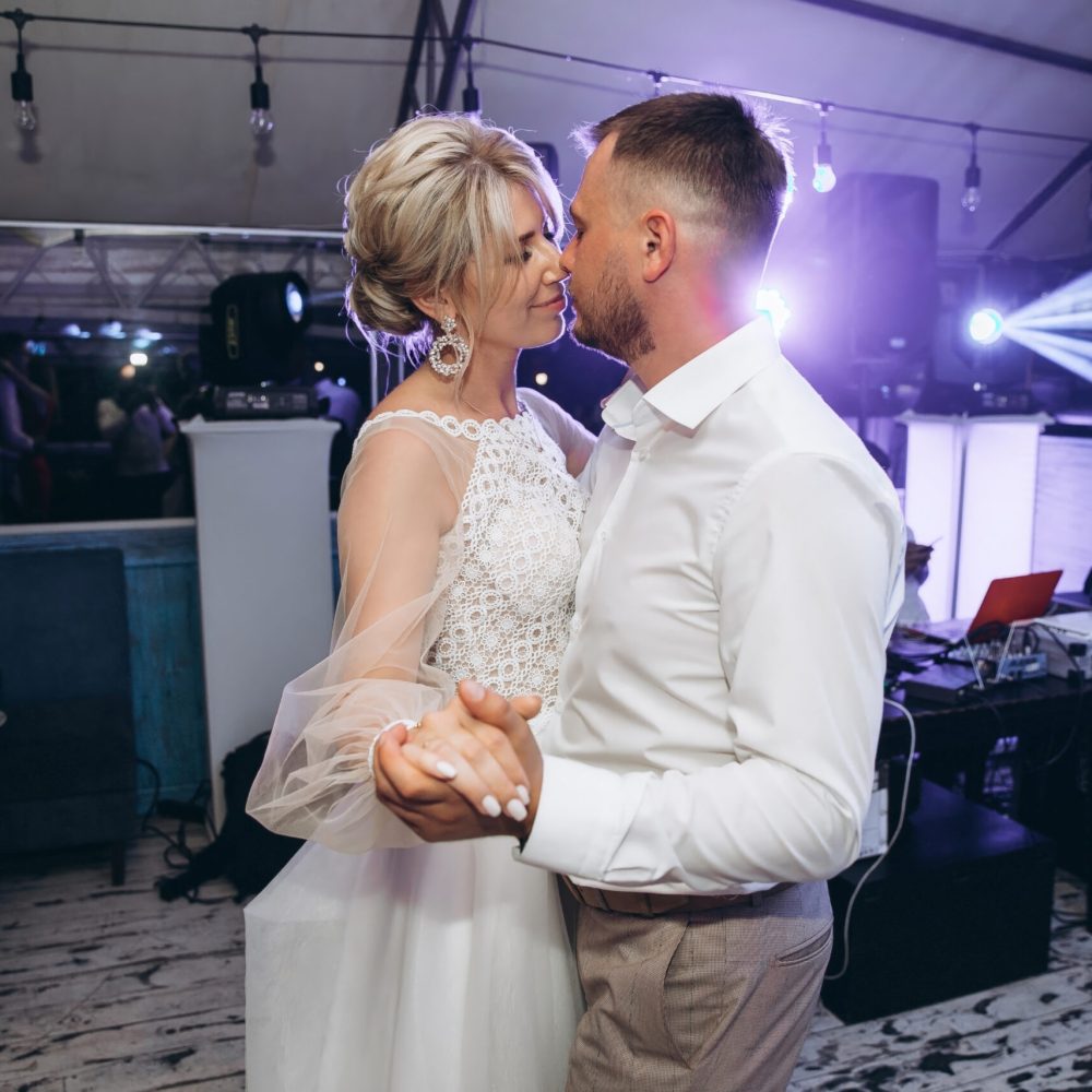 Bride and groom dancing the first wedding dance against the background evening restaurant